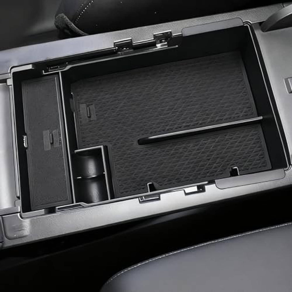 Black armrest cover with textured panels, central tray, and cup-holder opening