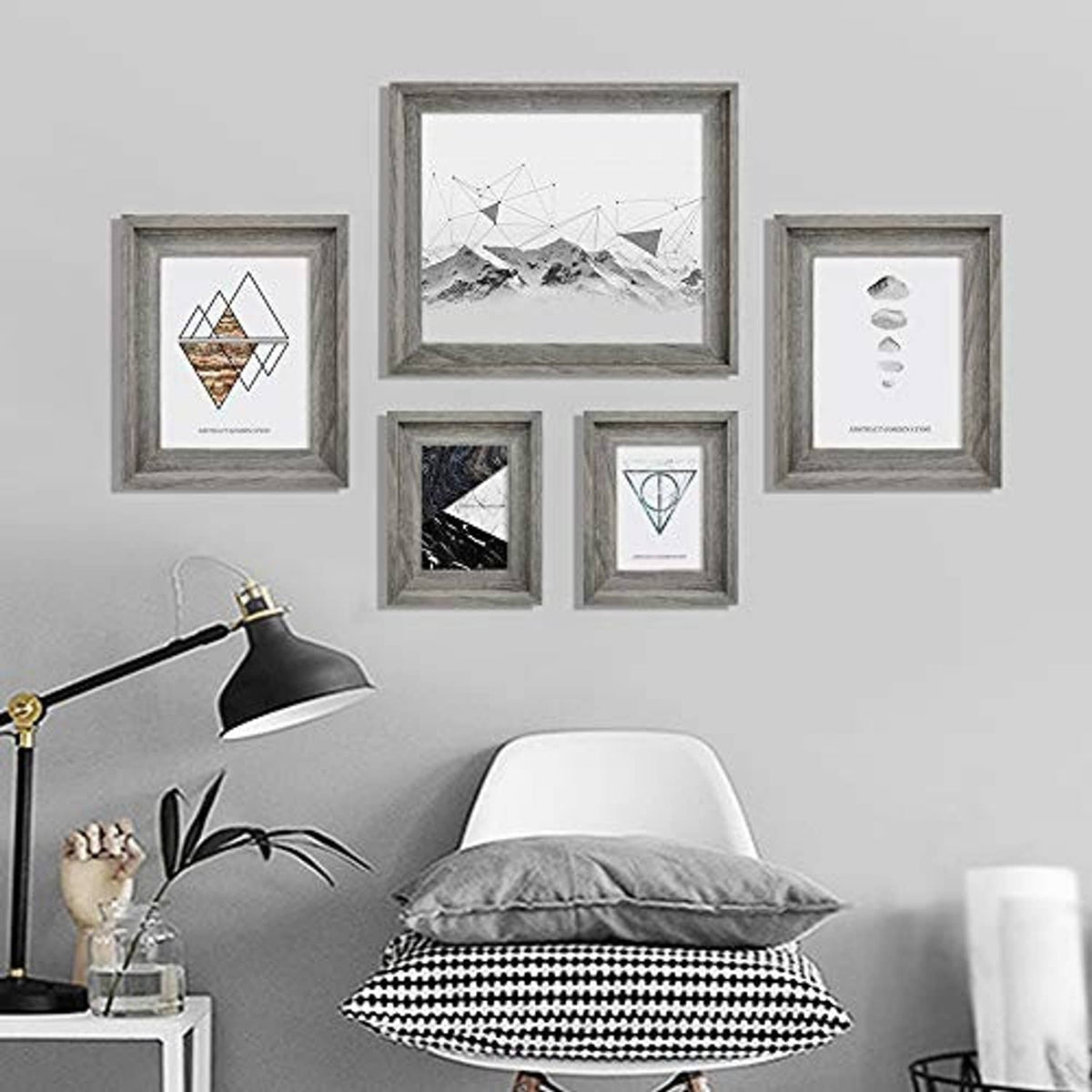 Wall display of distressed gray wooden picture frames in multiple sizes