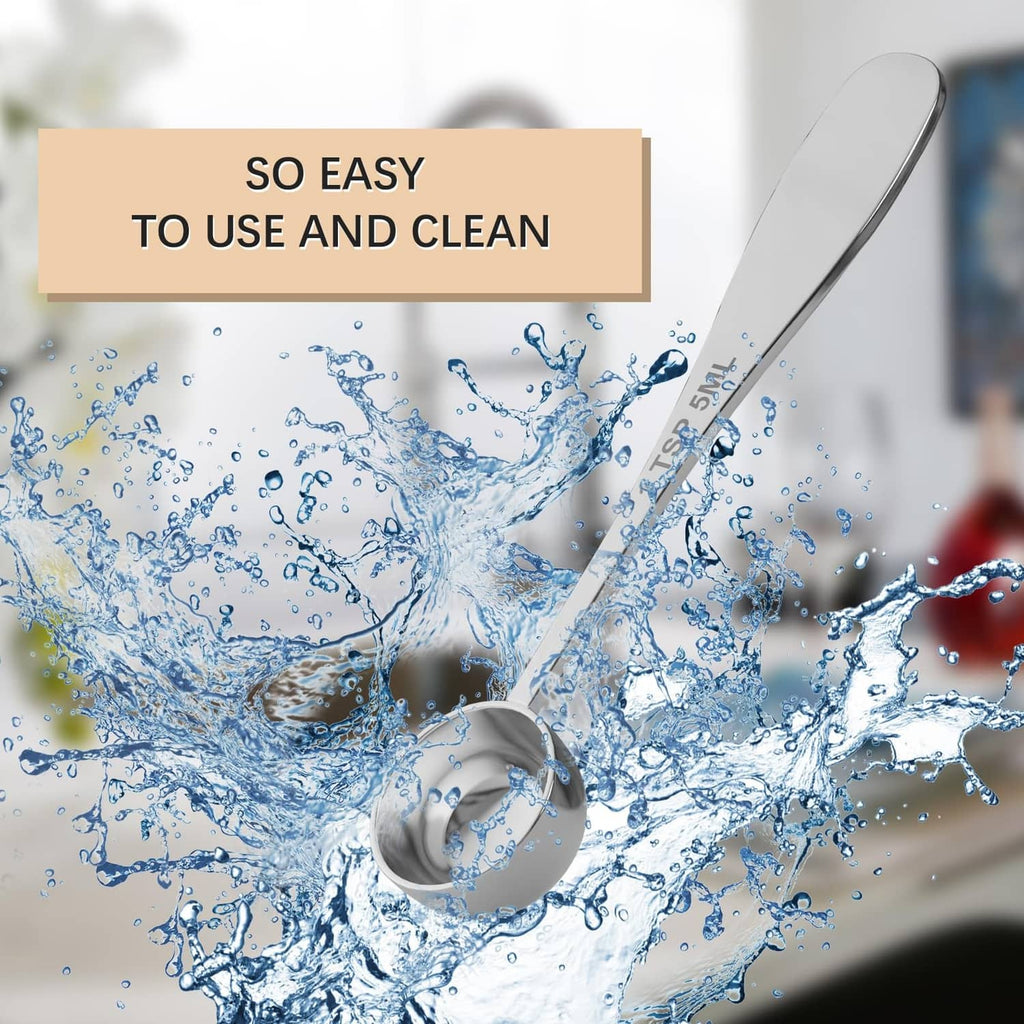 Stainless steel measuring spoon near water splash, designed for easy cleaning