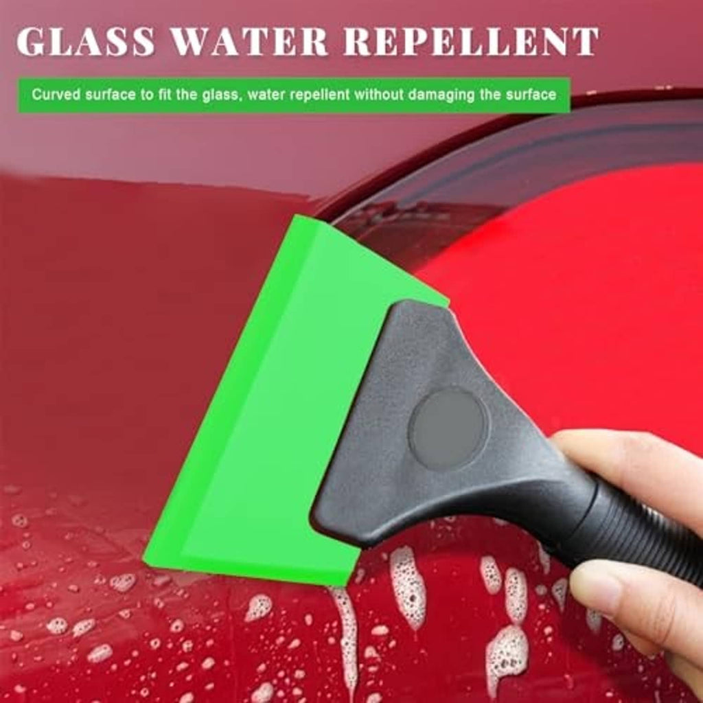 Window film squeegee tool with green blade pushing water off a car window