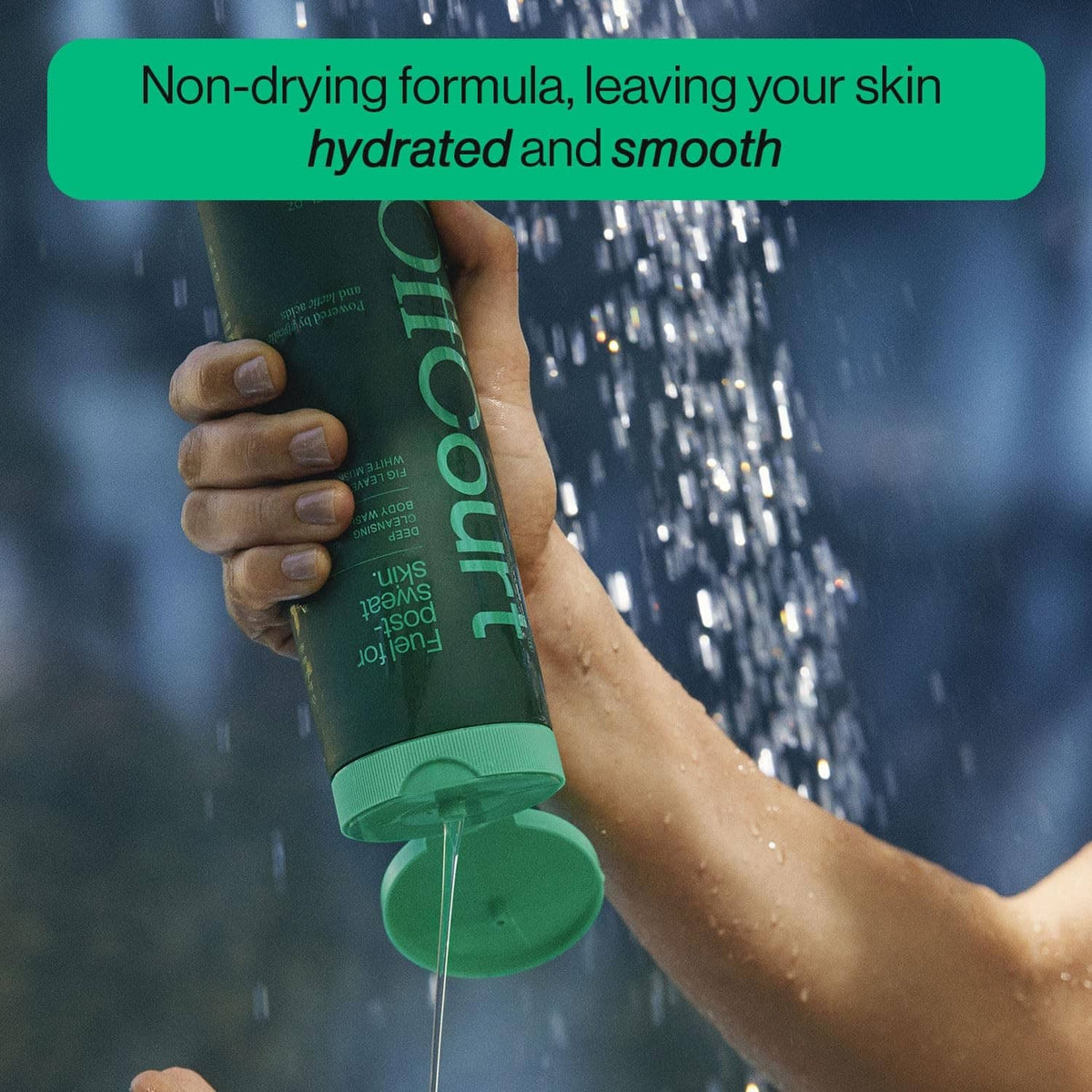 Hand holding Offcourt green shower gel bottle with cap open, water droplets