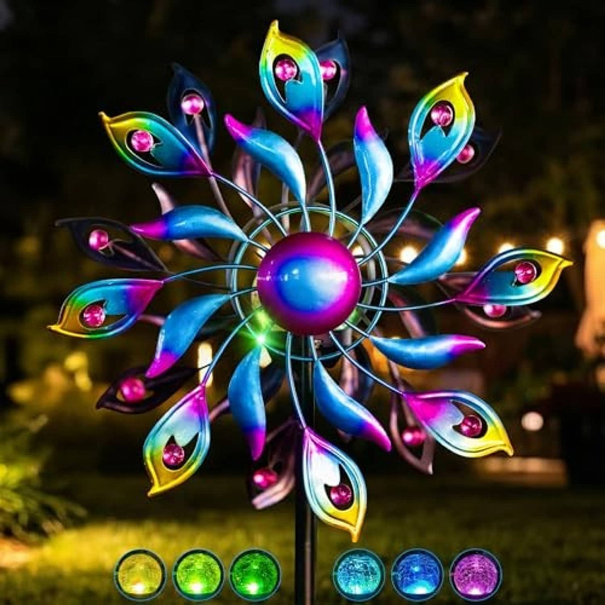 Colorful peacock metal wind spinner with glowing LED accents on a tall garden stake