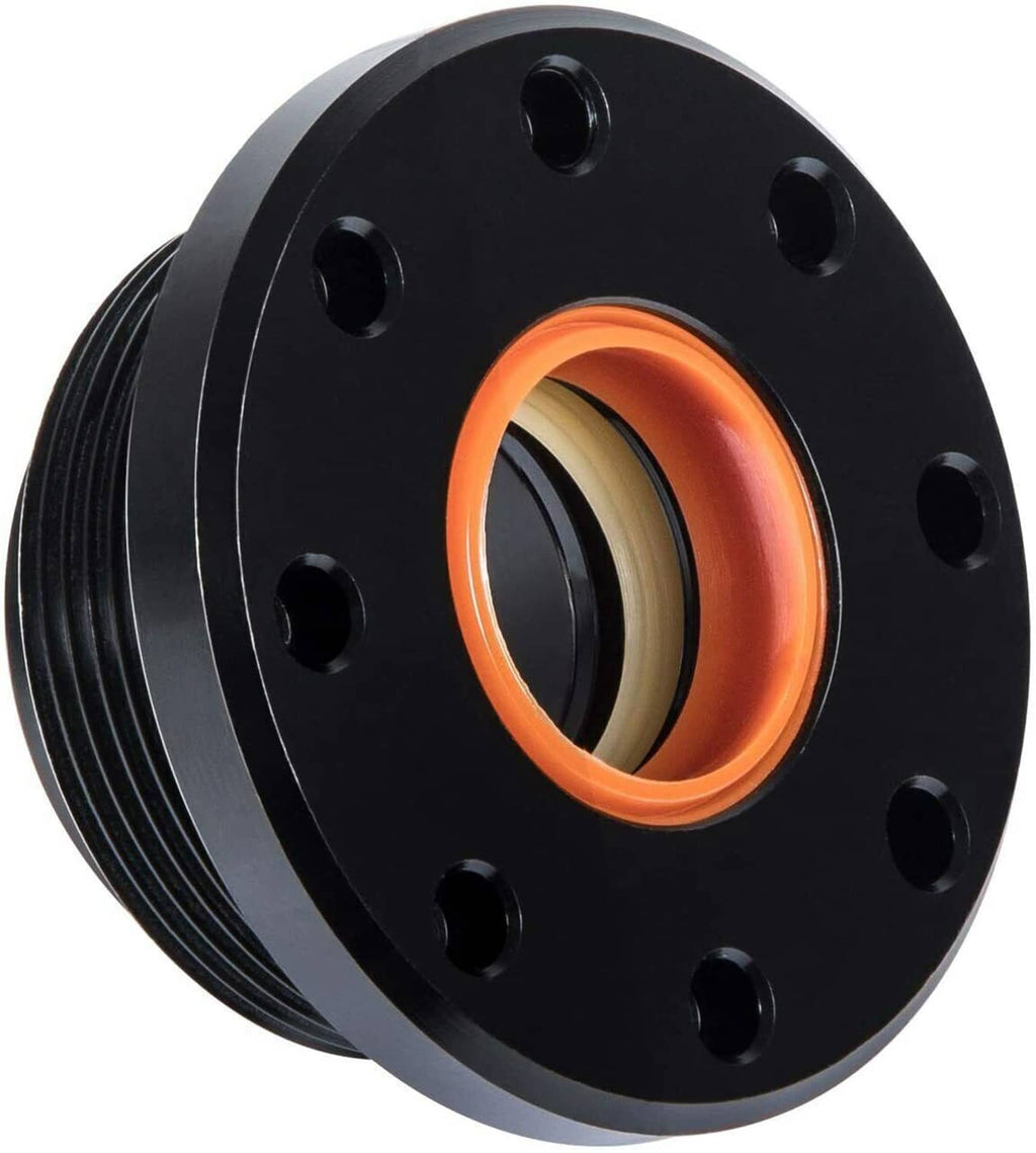 Stacked black steering seal housings with orange gasket ring and bolt holes