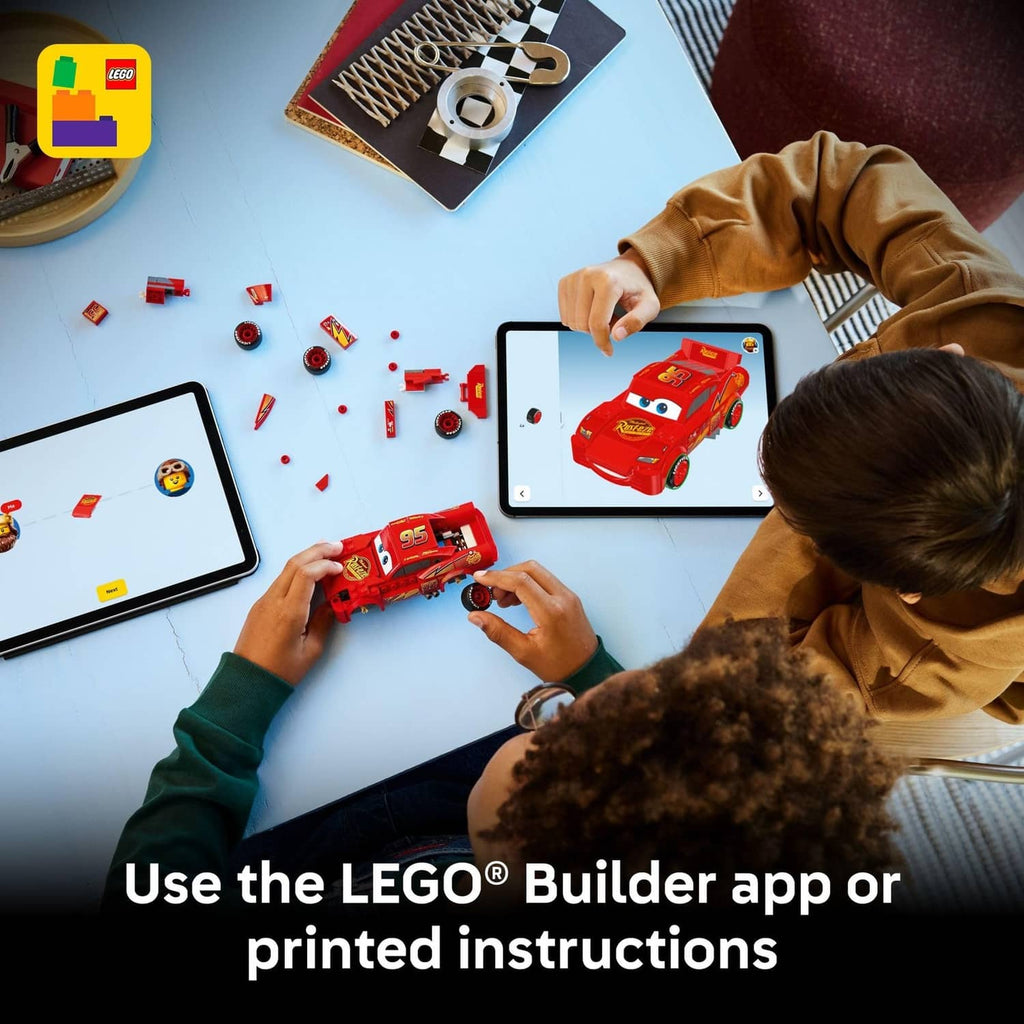 Red buildable race car toy in hands, with number 95 and lightning graphics