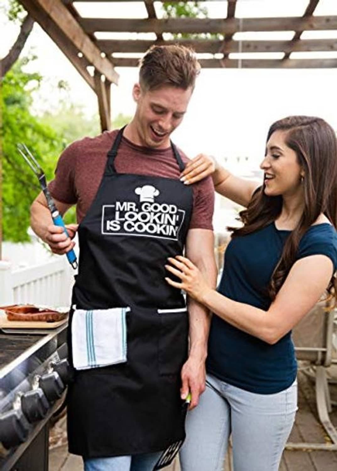 Black cooking apron with chest logo graphic, adjustable neck strap, and two front pockets