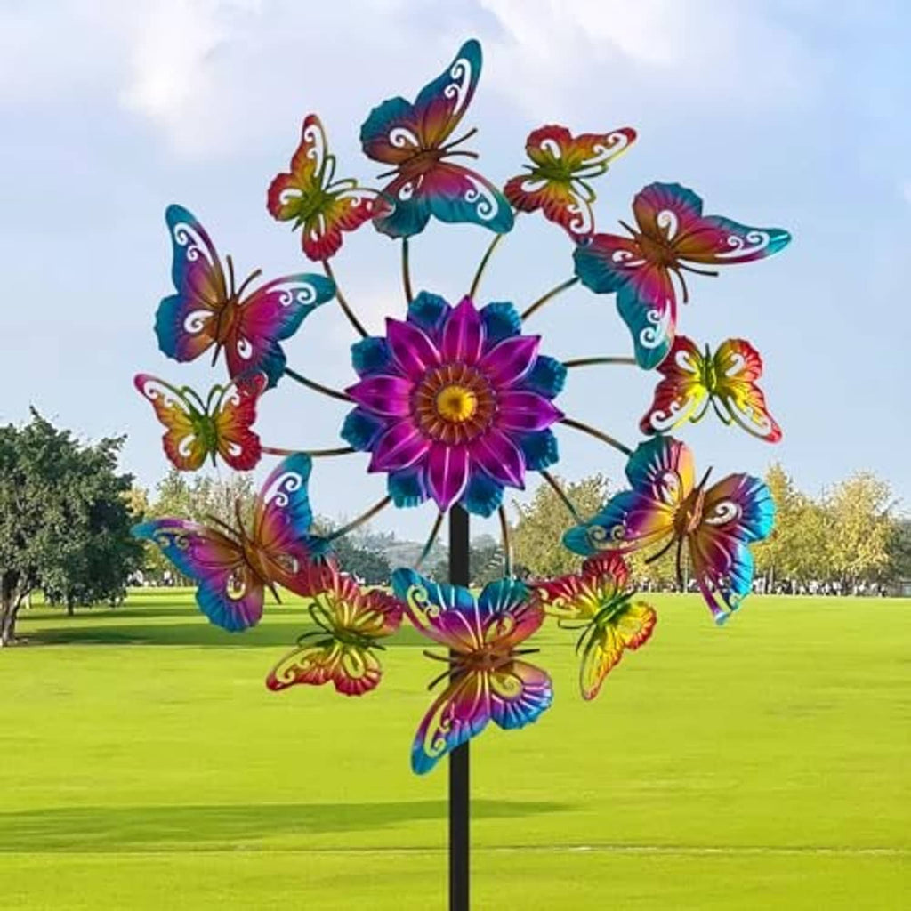 Multicolor butterfly wind spinner flower with curved metal blades on a black yard stake