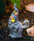 Solar garden gnome statue with glowing flower LEDs and clear bubble light, gray finish