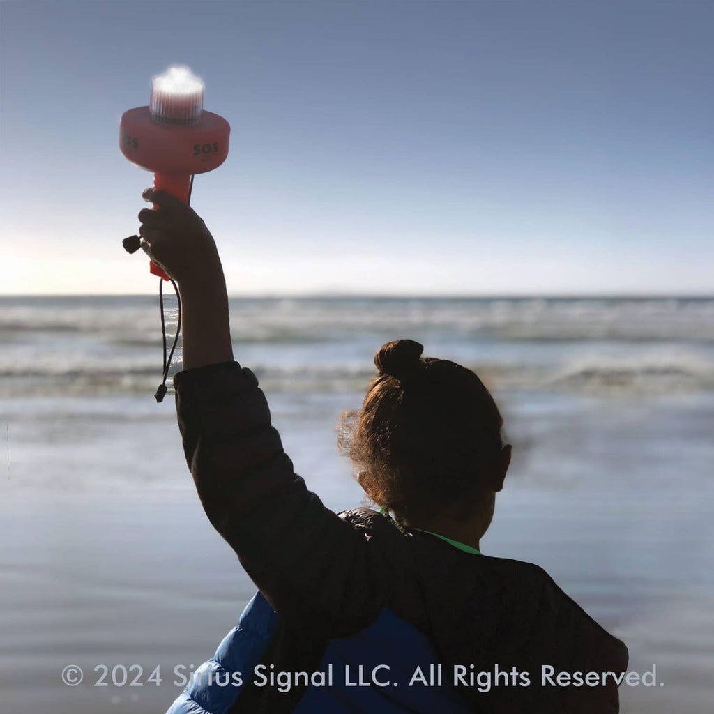 Red SOS LED distress flare held up for signaling with clear top beacon