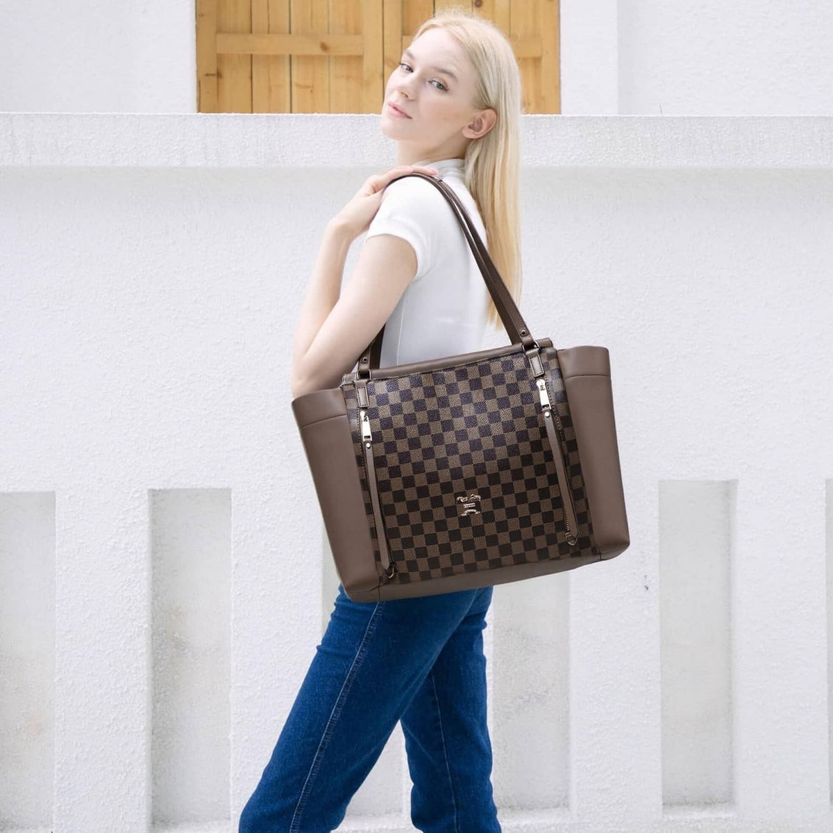Checkered diaper bag tote on model with brown side panels and double top handles