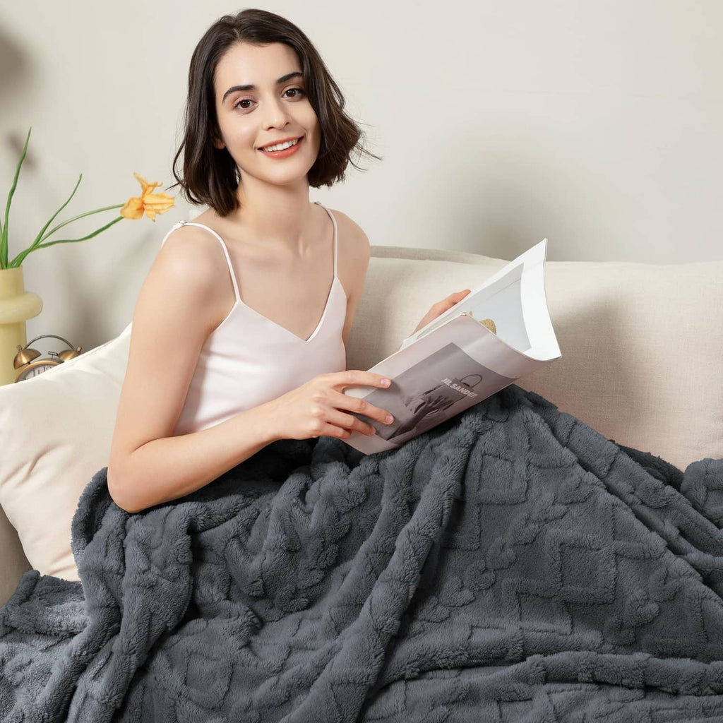 Gray plush blanket with bold raised pattern and soft, cozy drape