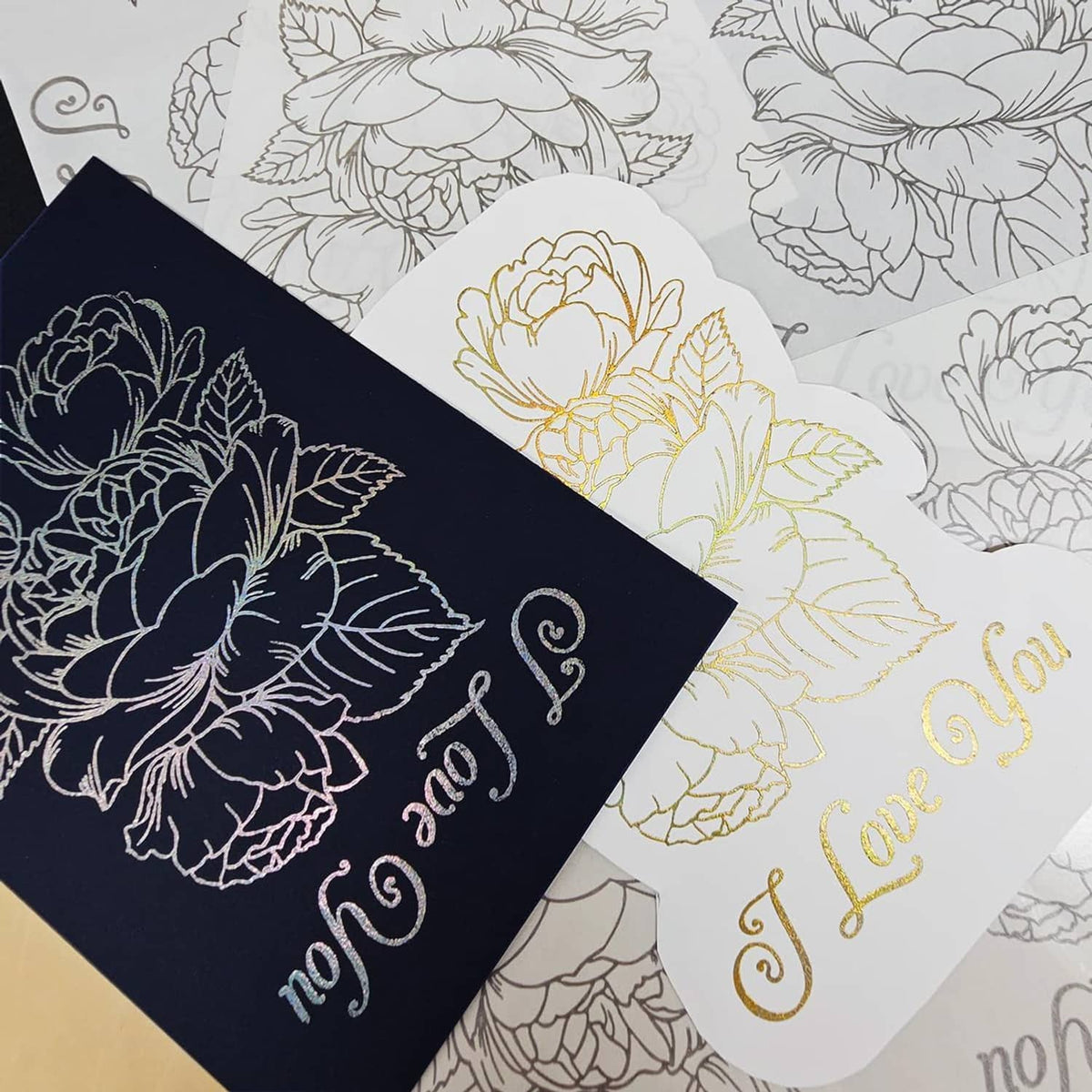 Close-up of floral “I Love You” foil transfer stickers in navy and gold tones