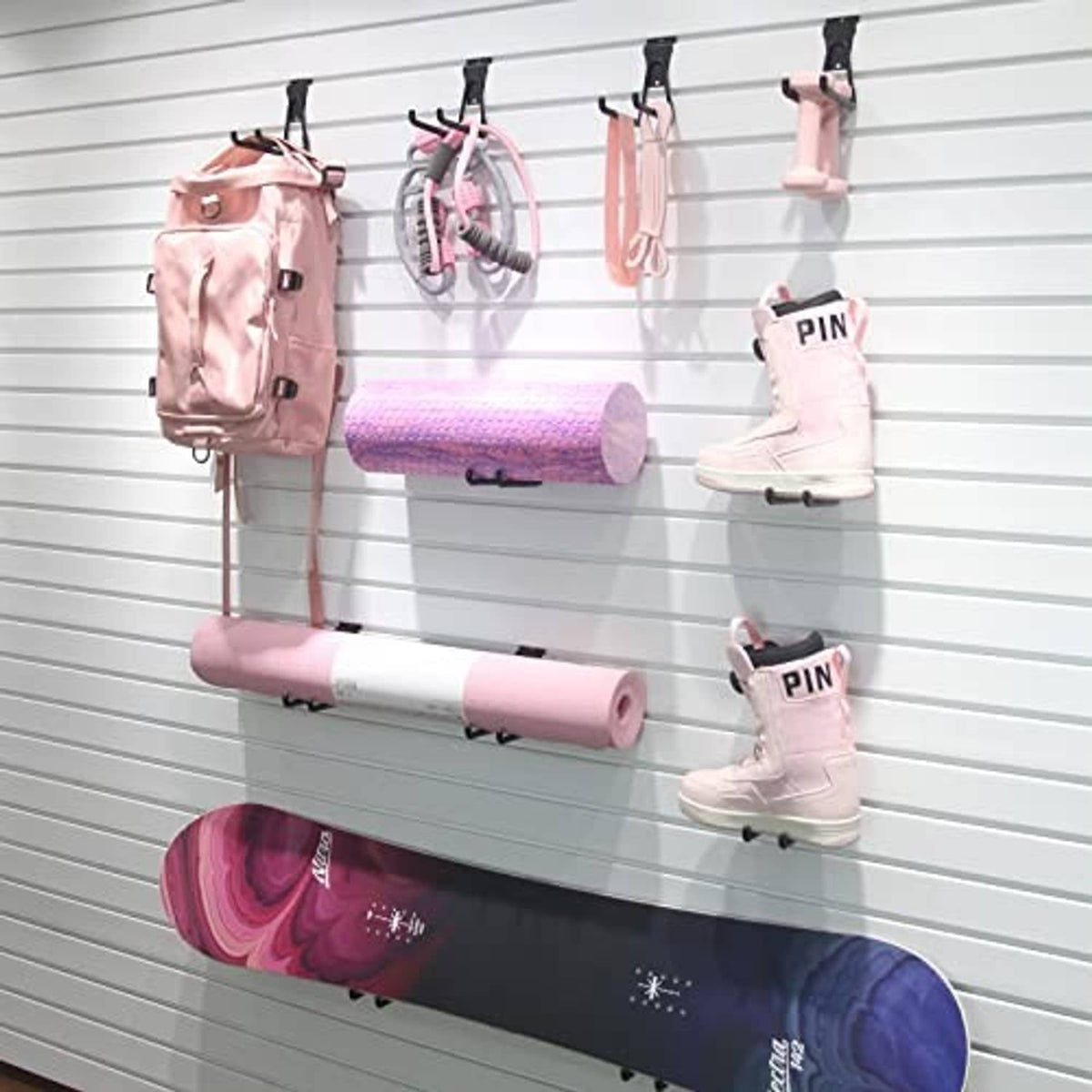 Black slatwall U hooks mounted on slatwall, holding hanging accessories by curved arms