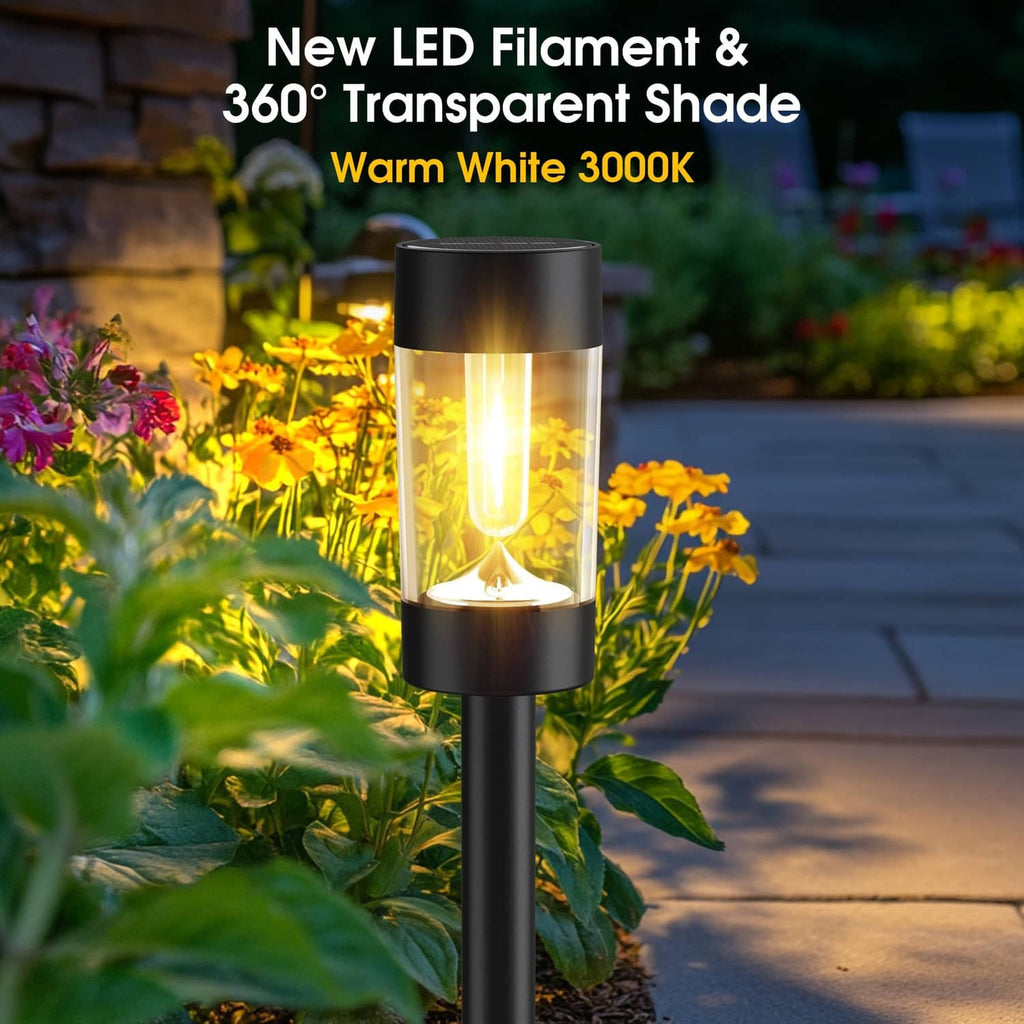 Single black solar pathway light with clear lantern shade and warm white glow