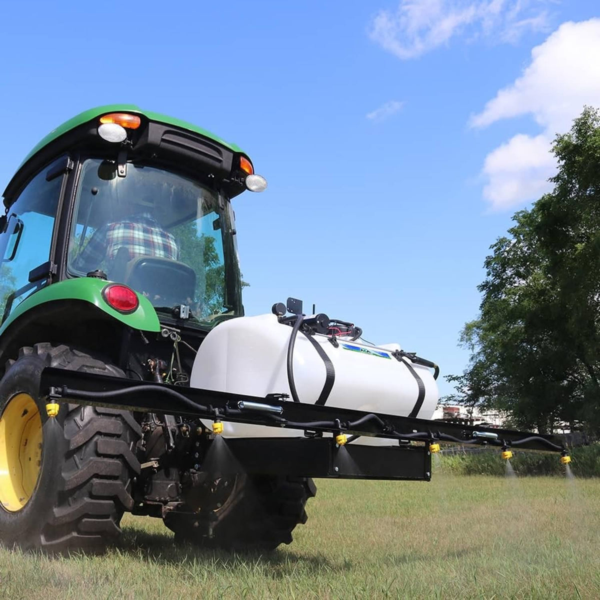 Sprayer unit with black diaphragm pump and white tank mounted on tractor