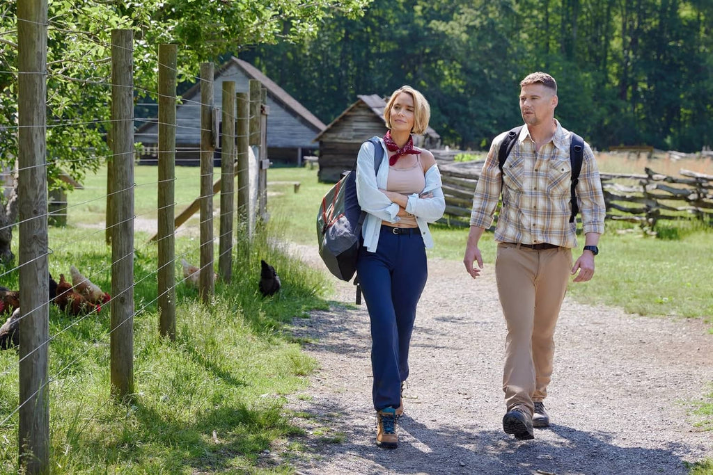 Romantic couple walking on a country path outdoors, woman carrying bag