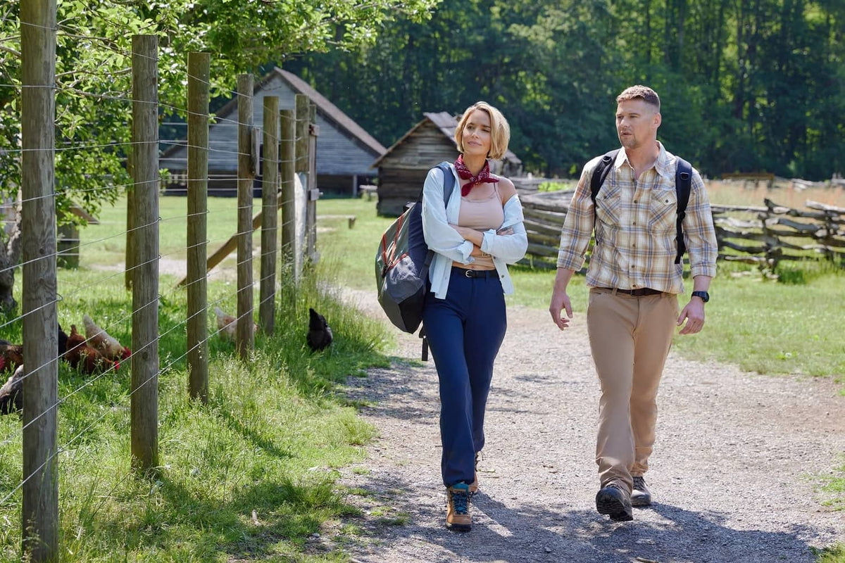 Romantic couple walking on a country path outdoors, woman carrying bag