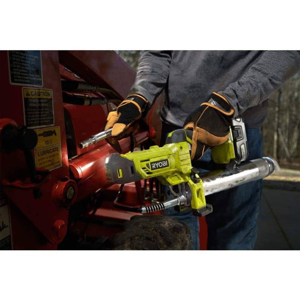 Cordless grease gun being used to apply lubricant to a red engine part