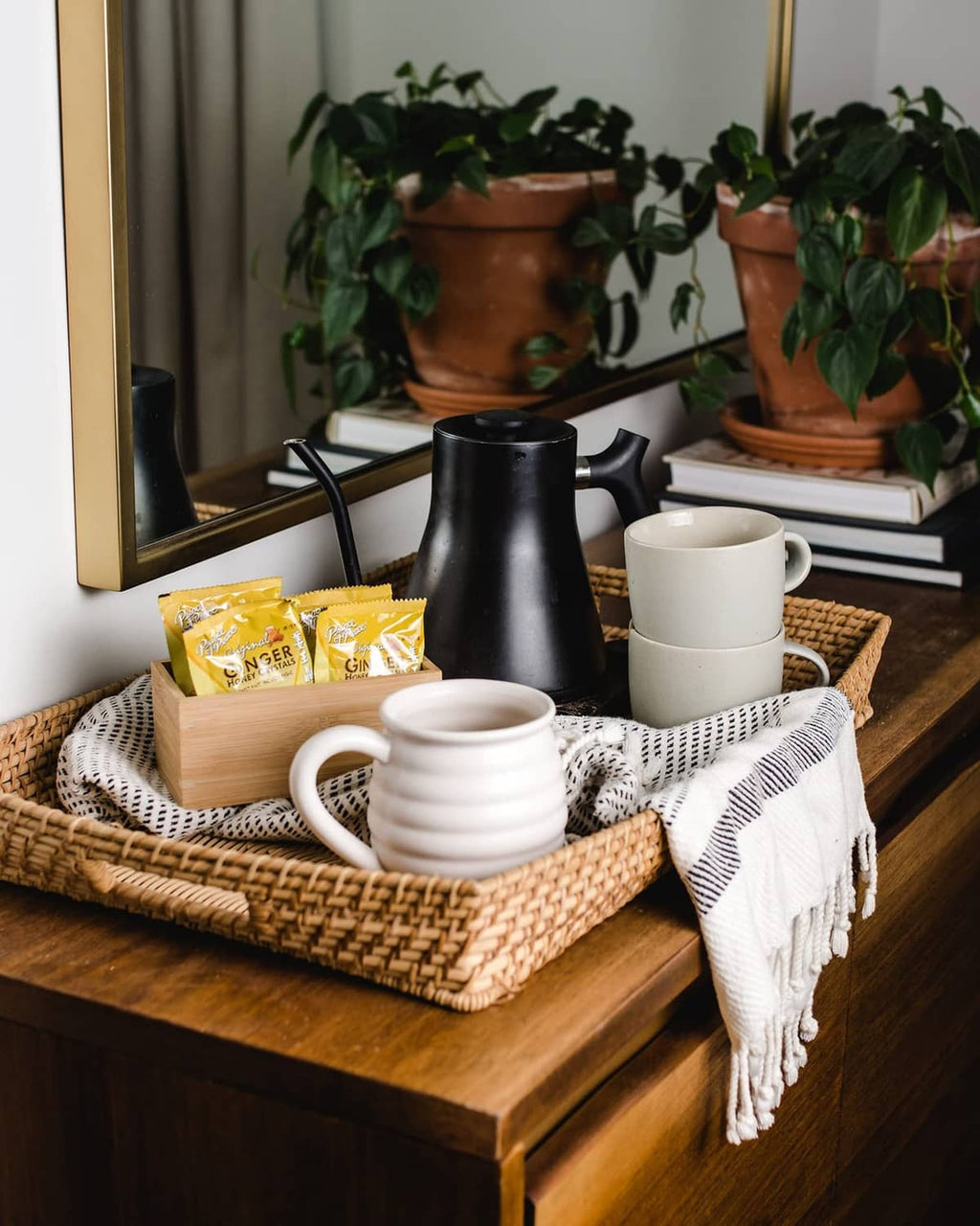 Ginger honey crystals sachets on a basket with mugs and a kettle nearby