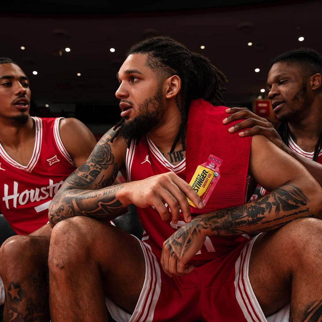 Honey Stinger energy gel packet held by basketball players in red jerseys