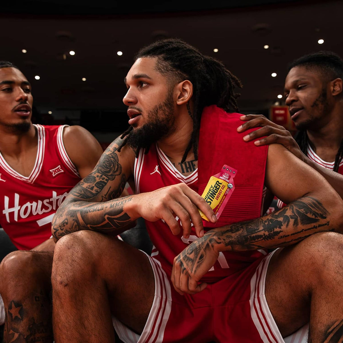 Honey Stinger energy gel packet held by basketball players in red jerseys