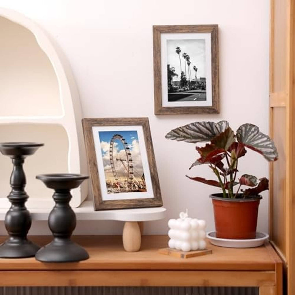 Rustic brown picture frames with white mats on tabletop shelf, home decor.