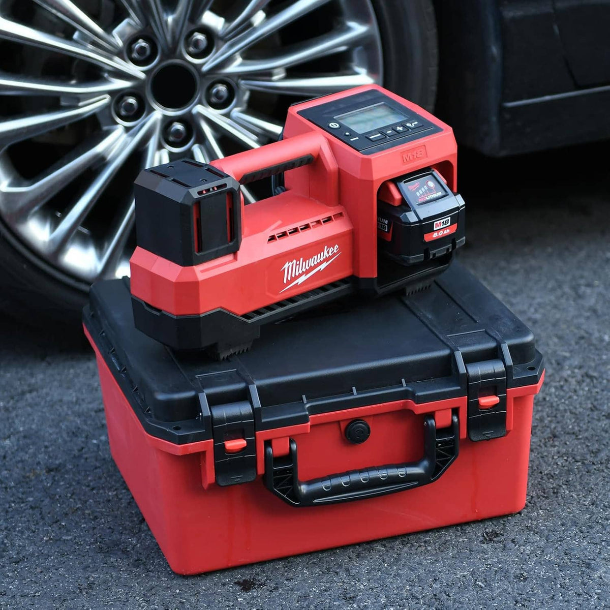 Red-and-black hard case with accessories and batteries resting in open tray