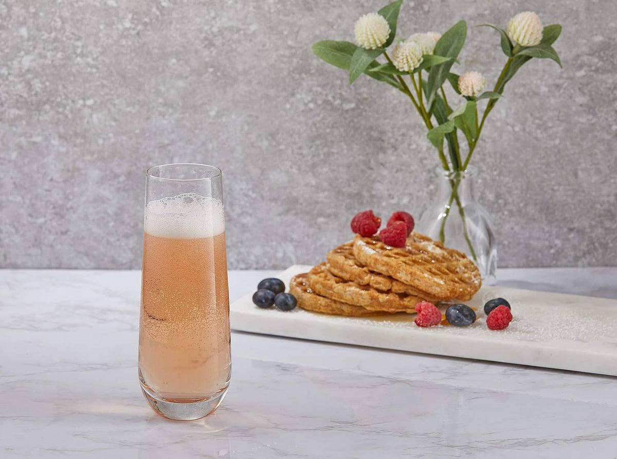 Stemless champagne flute with golden sparkling drink and foam on a tabletop