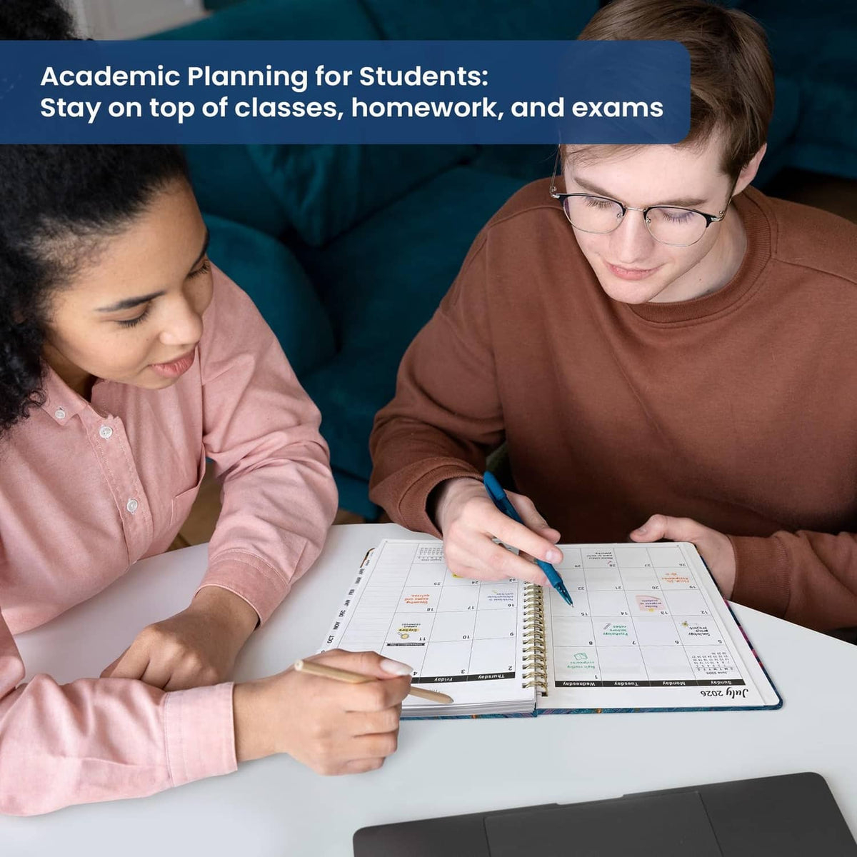 Student writes in open academic planner on desk, gold spiral binding visible