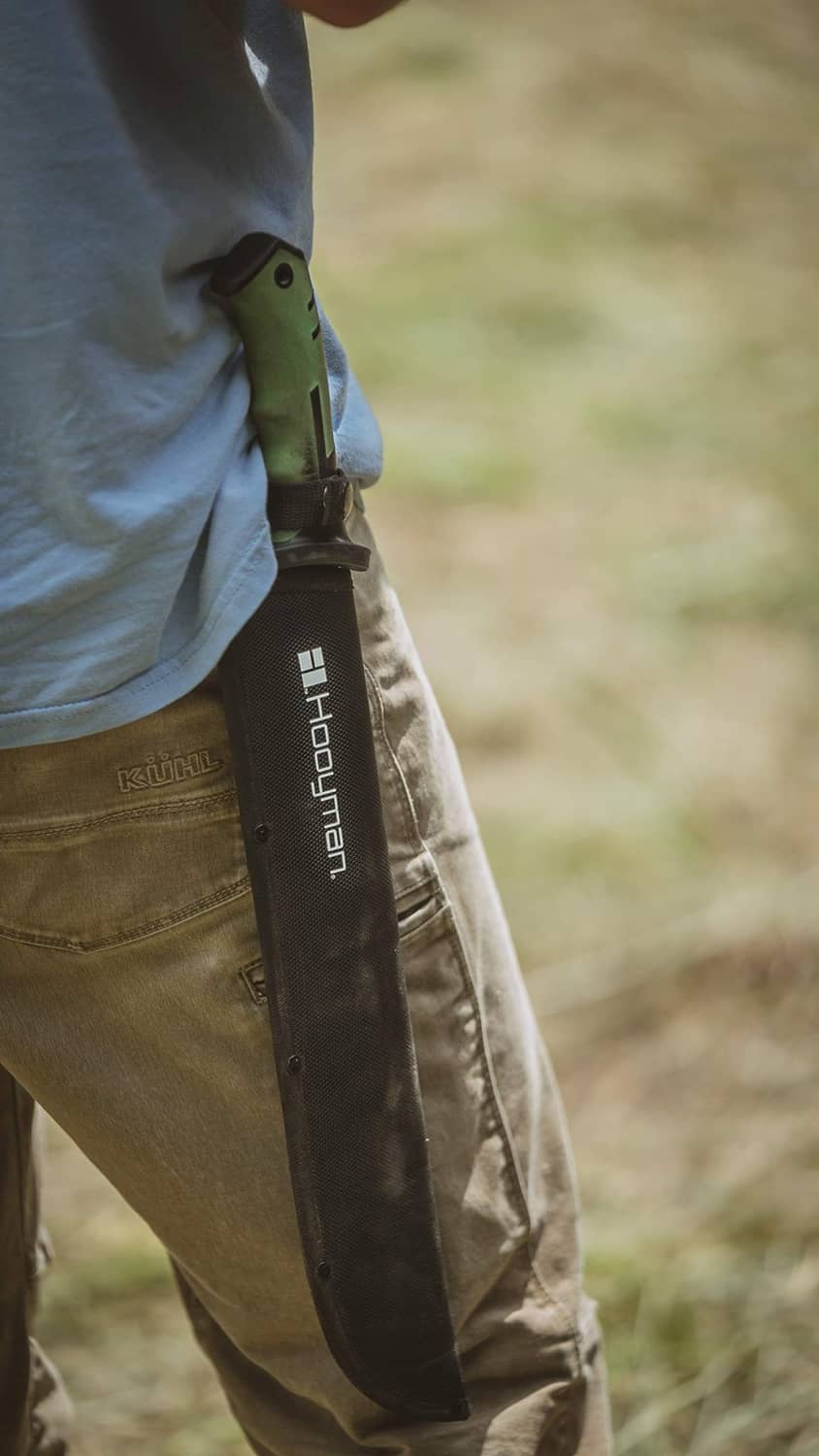 Hooyman bush machete in black sheath on belt, green handle visible
