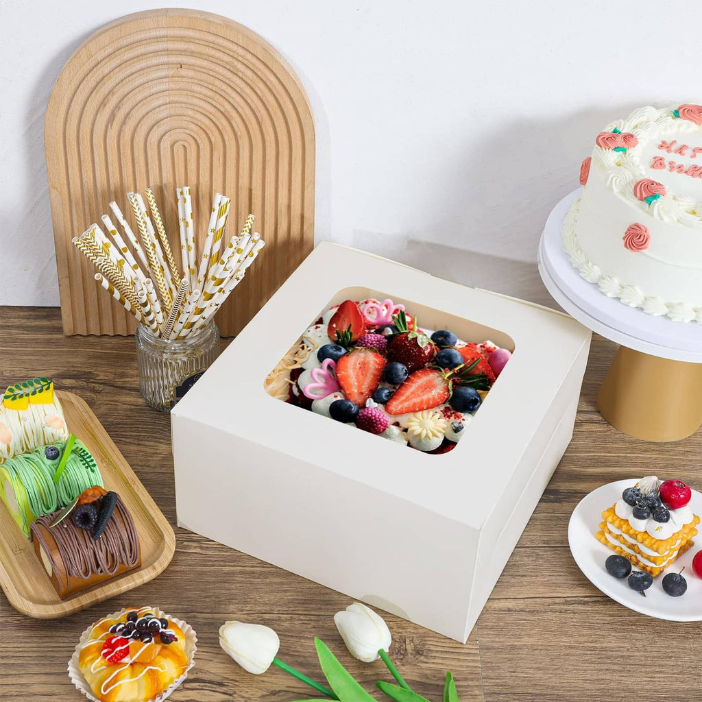 White square cake box with open top, displaying a cake with berries inside.
