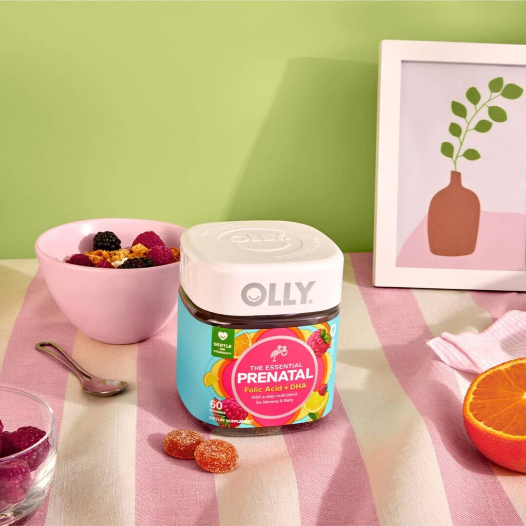 OLLY prenatal gummy bottle with lid beside scattered red and orange gummies