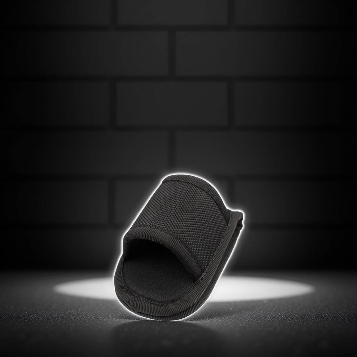 Open-top black flashlight holder pouch with curved opening and stitched edge.