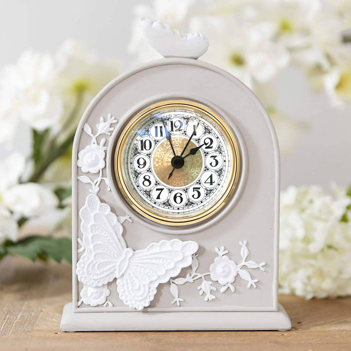 Mini quartz clock insert set in a white arched frame with floral relief