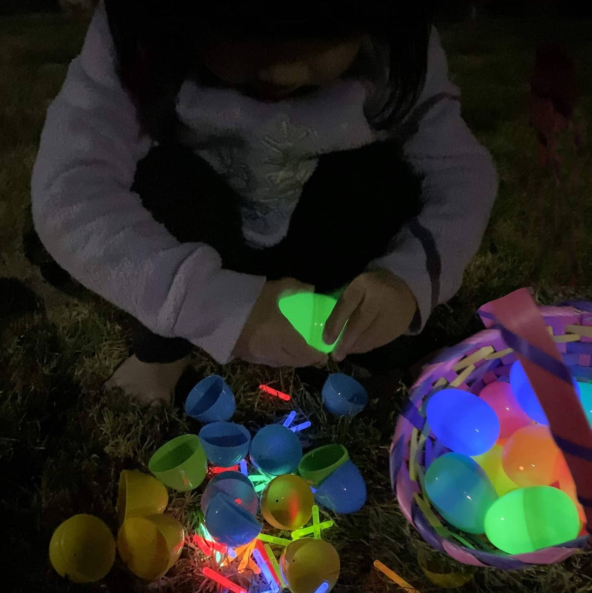 Mini glow sticks and a child playing outdoors, glowing green, blue, red, and yellow