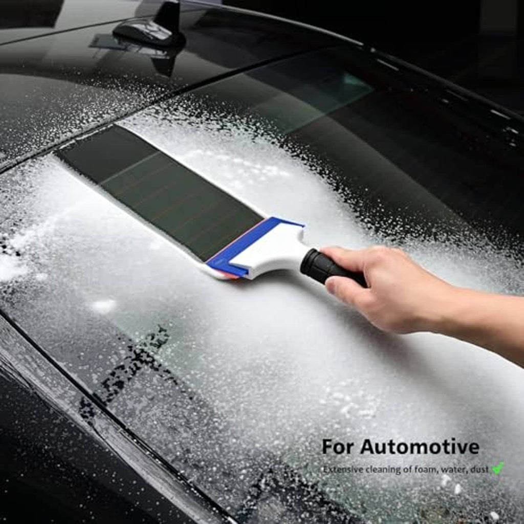 Double-edge squeegee with white blade and black handle clearing water foam from car glass.
