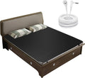 Grounding mattress pad on bed with dark grid-textured cover and coiled grounding cord