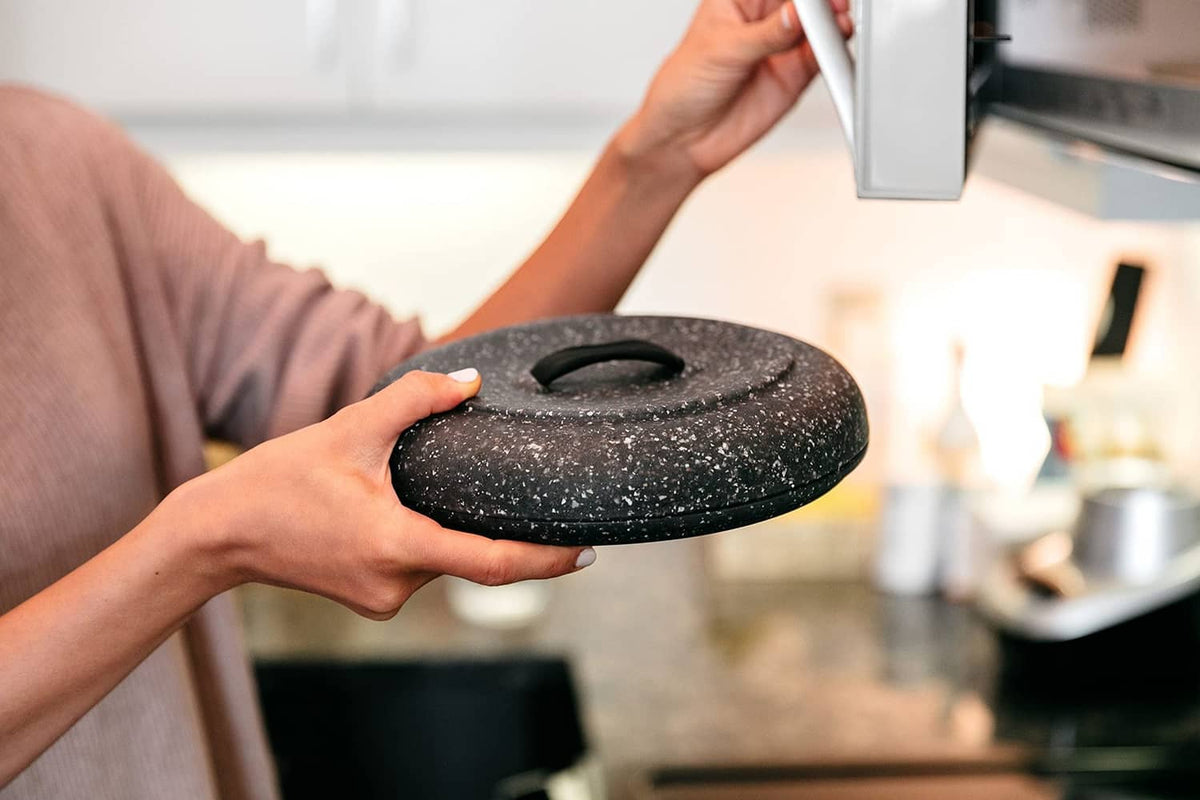 Granite-pattern tortilla warmer lid held in hand with textured black granite finish