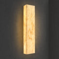 Rectangular natural marble wall sconce with warm amber glow and vertical light panel