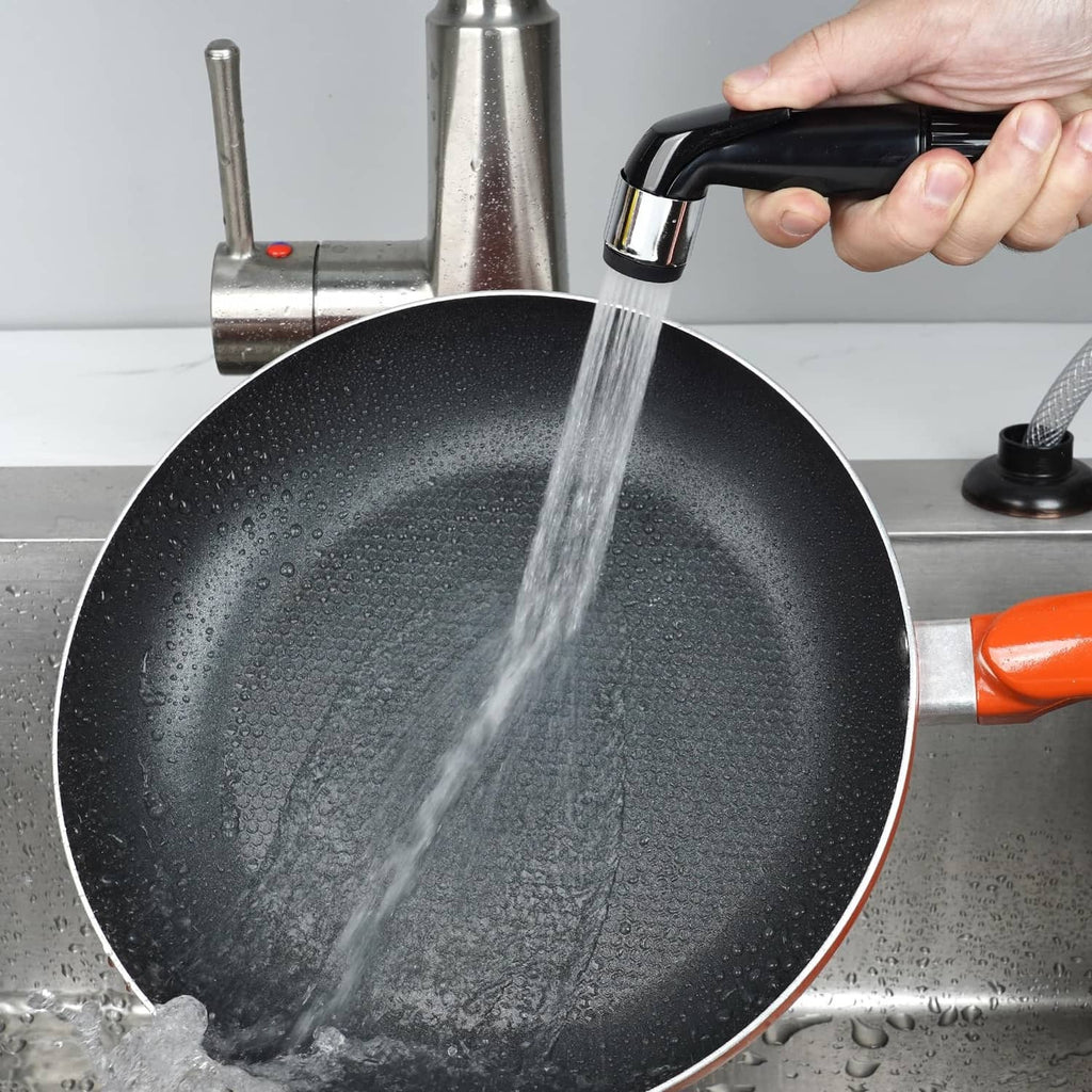 Matte black sprayer attachment rinsing a pan under running water