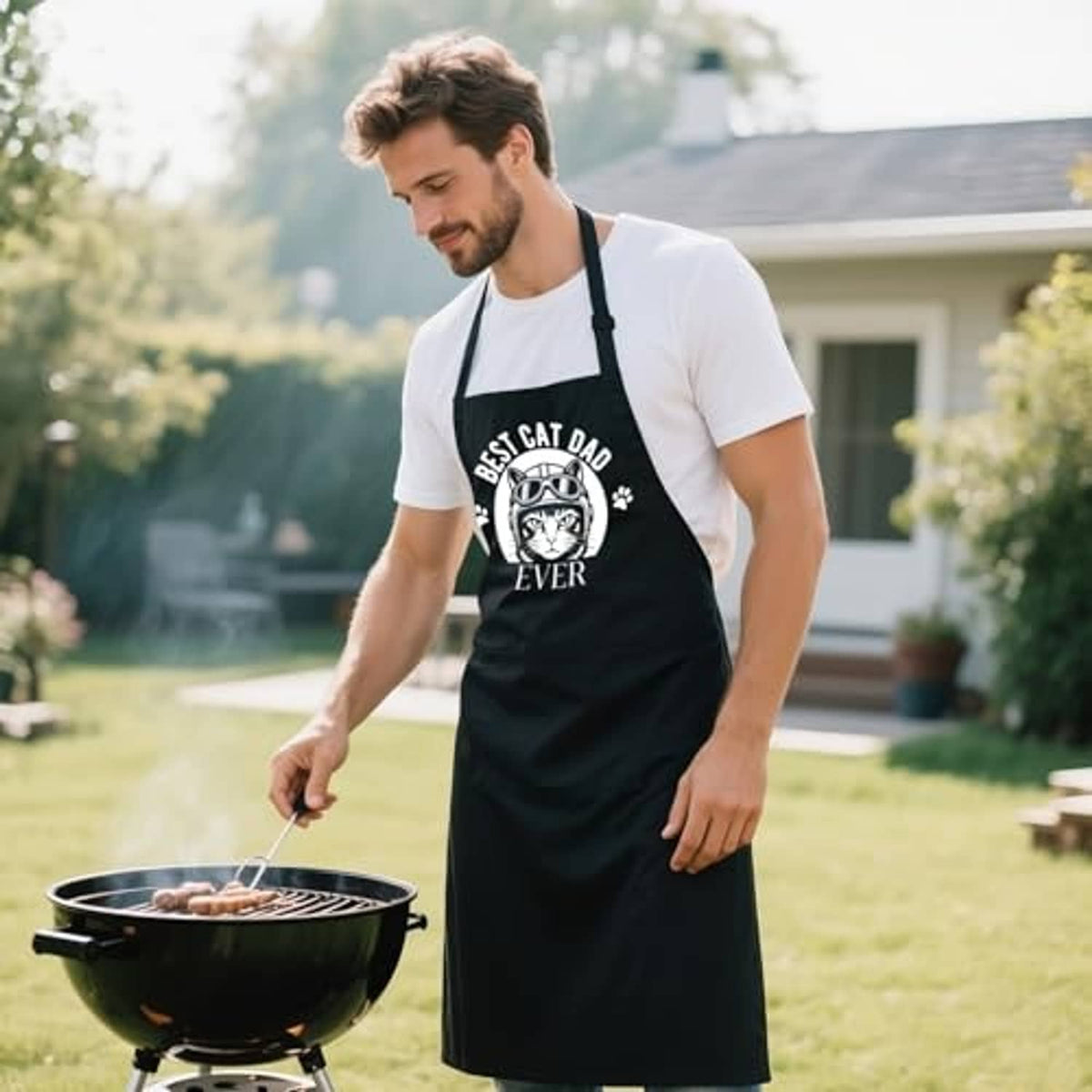Black BBQ apron with 'Best Cat Dad Ever' cat print and adjustable neck strap.