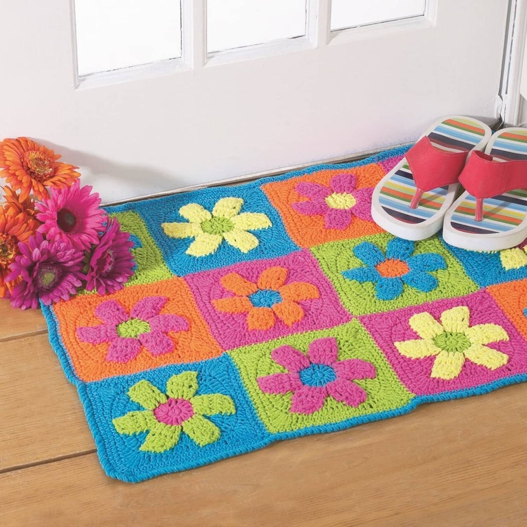 Colorful crocheted square blanket or mat with bright flower motifs