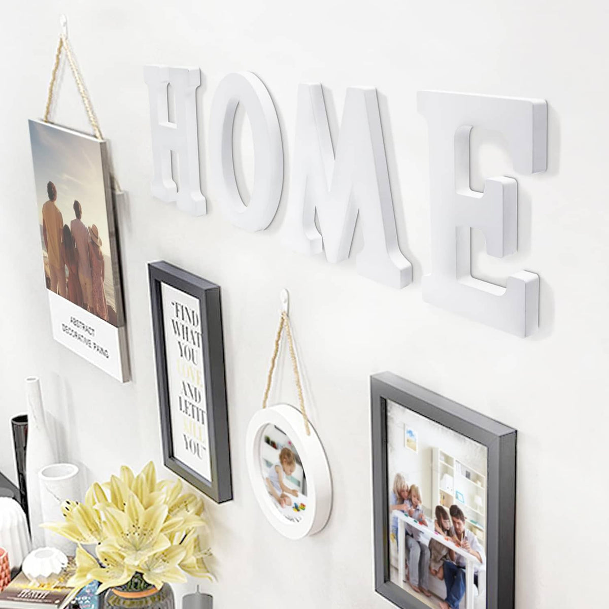 White wooden wall letters HOME, mounted with hanging frames