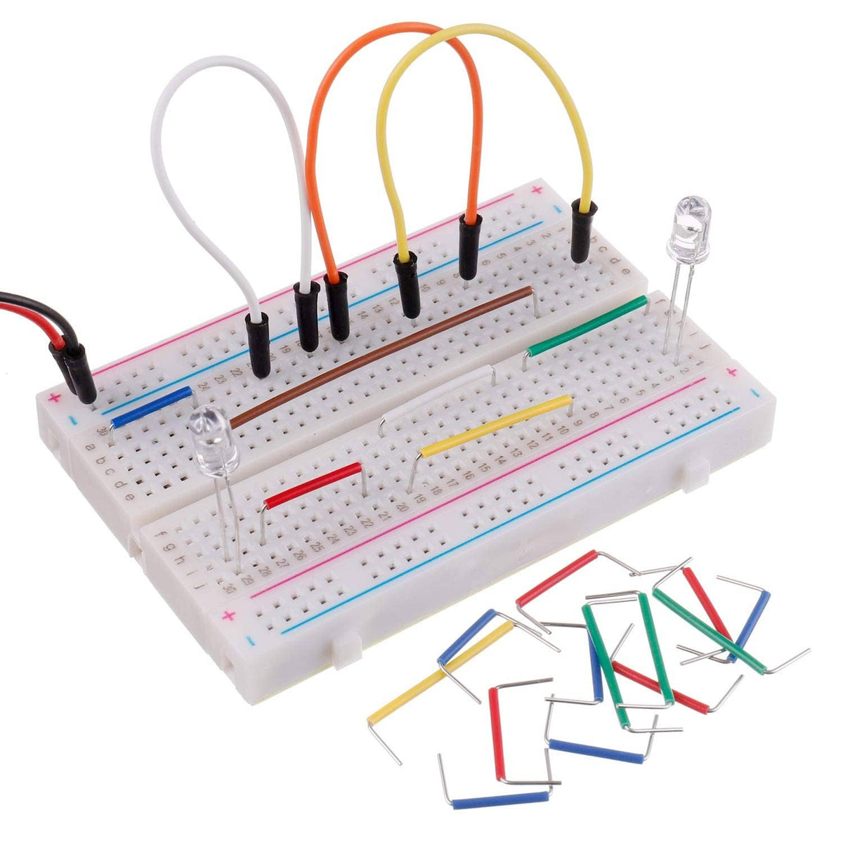 Breadboard with connected jumper wires (orange, yellow, white) and loose pin wires