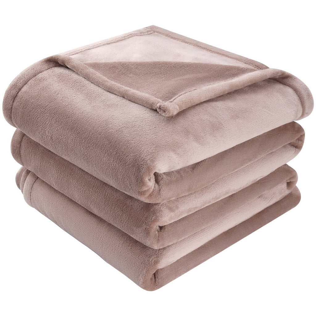 Taupe plush throw blanket folded into square stack, corner edge visible