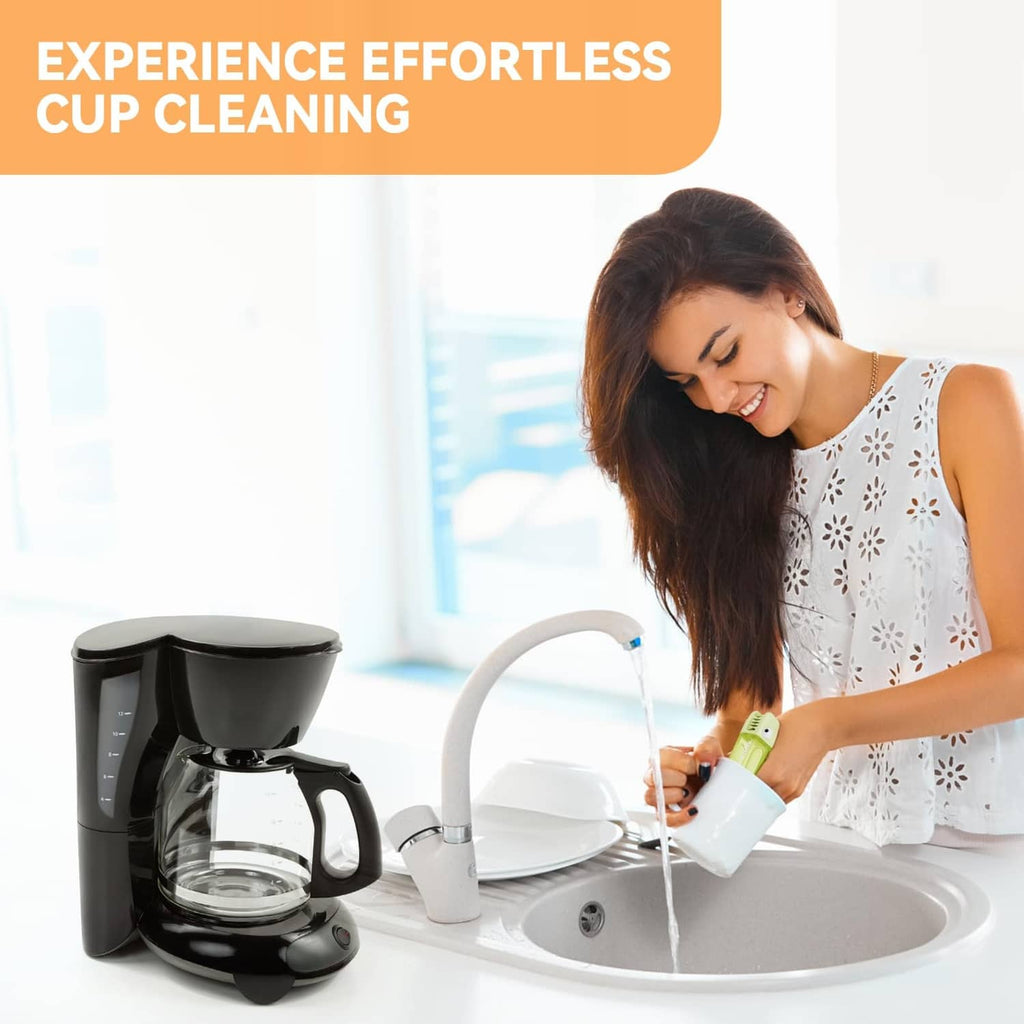Green cup cleaning brush used near a countertop coffee maker