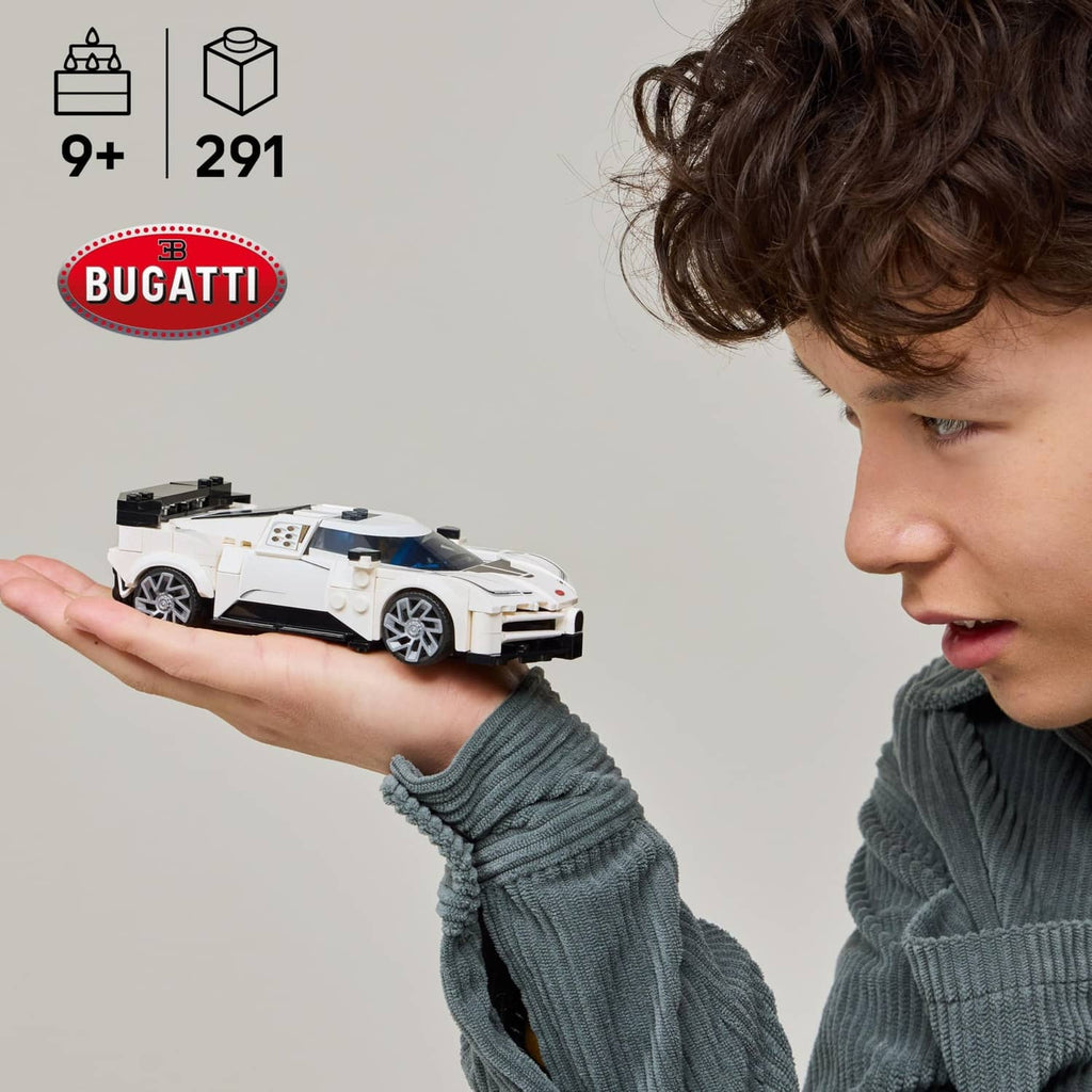 White and black LEGO toy sports car with a minifigure standing beside it
