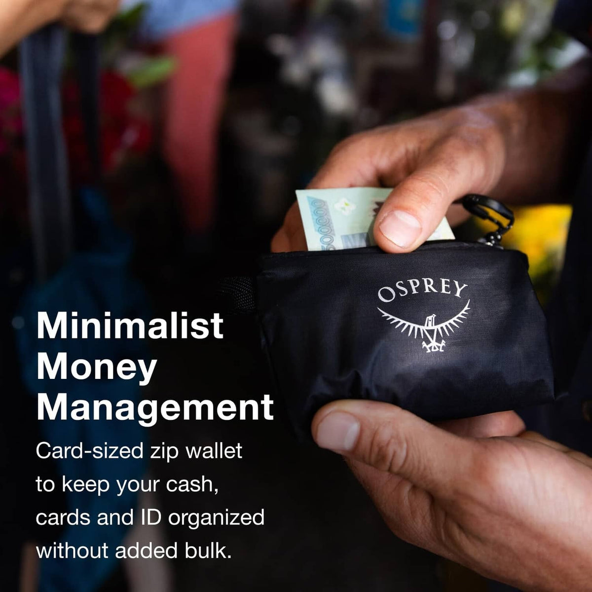 Osprey zip money wallet, dark color, held in hand with logo on front