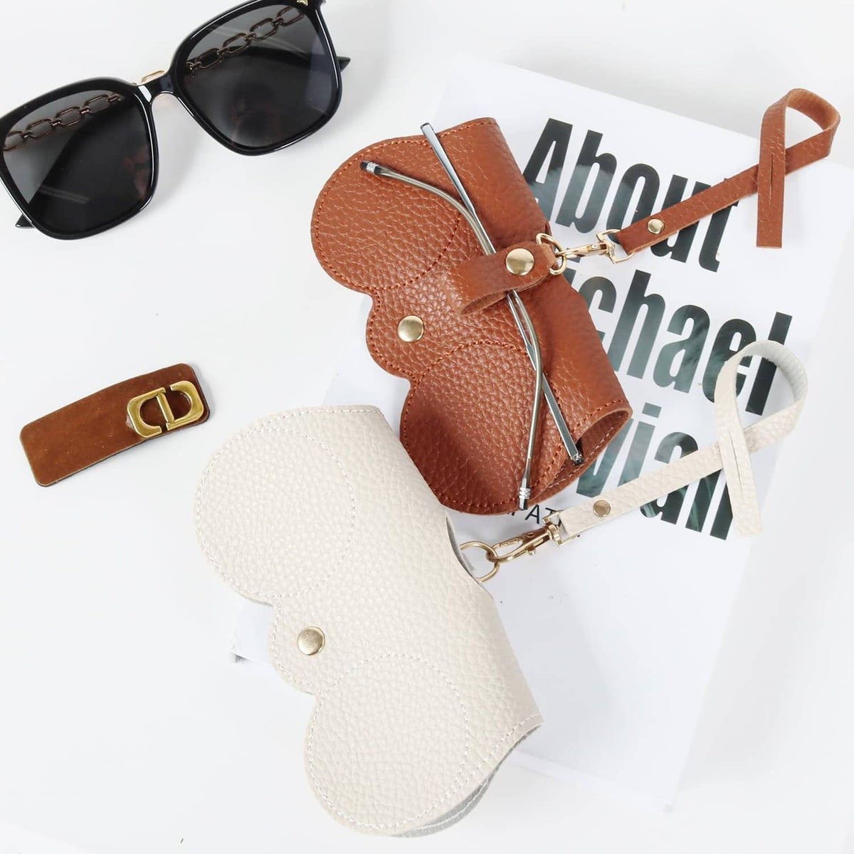 Brown and white soft leather sunglasses bags with wrist straps and snap closures