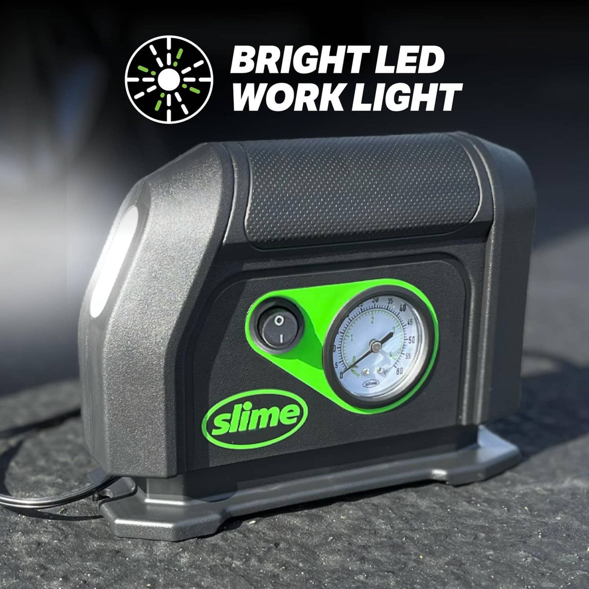 Compact tire inflator close-up with bright LED work light and analog pressure dial