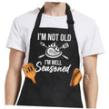Black apron front with neck strap and 'I'm not old, I'm well seasoned' lettering
